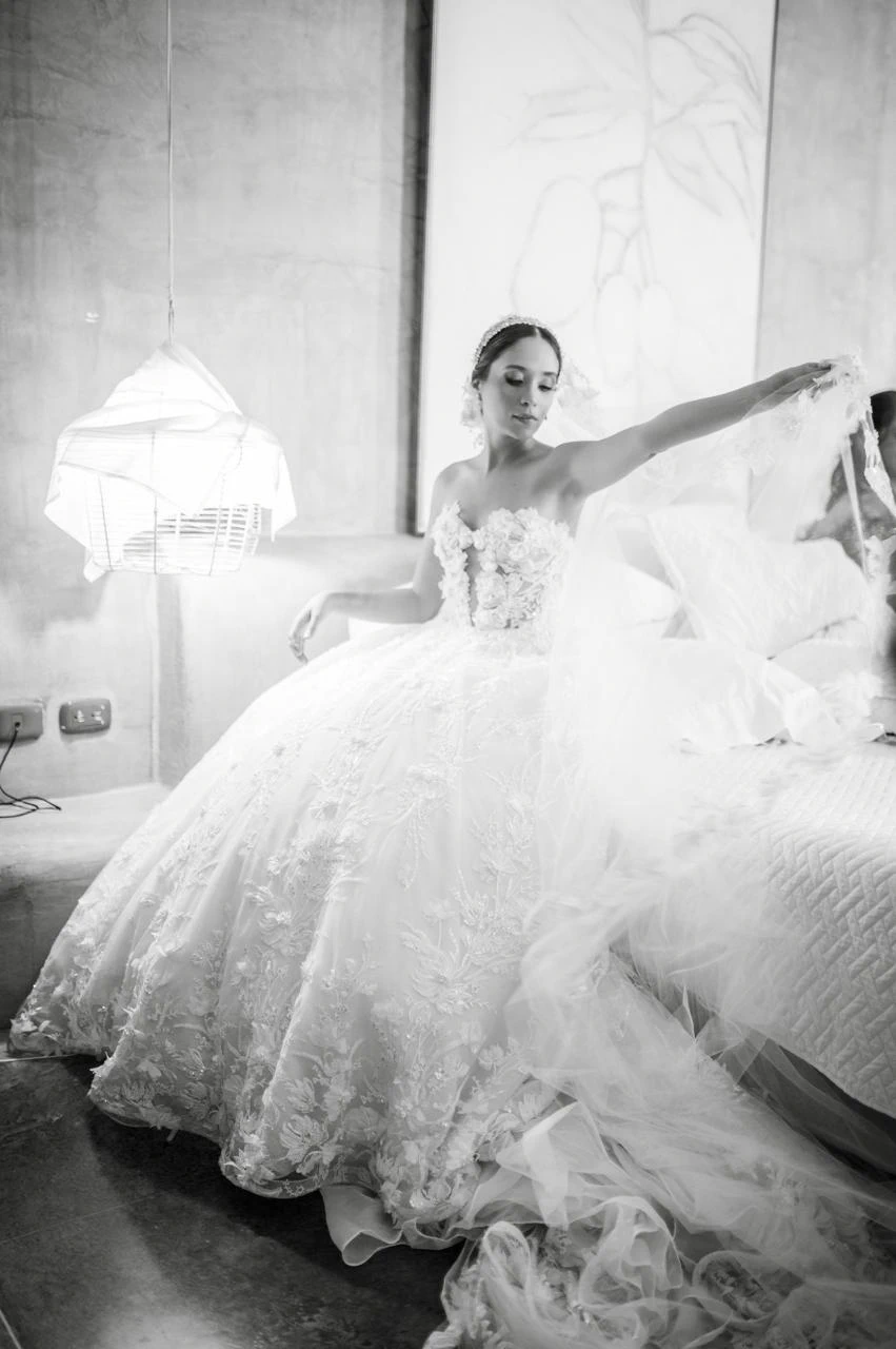 Novia con vestido de encaje extendiendo su velo